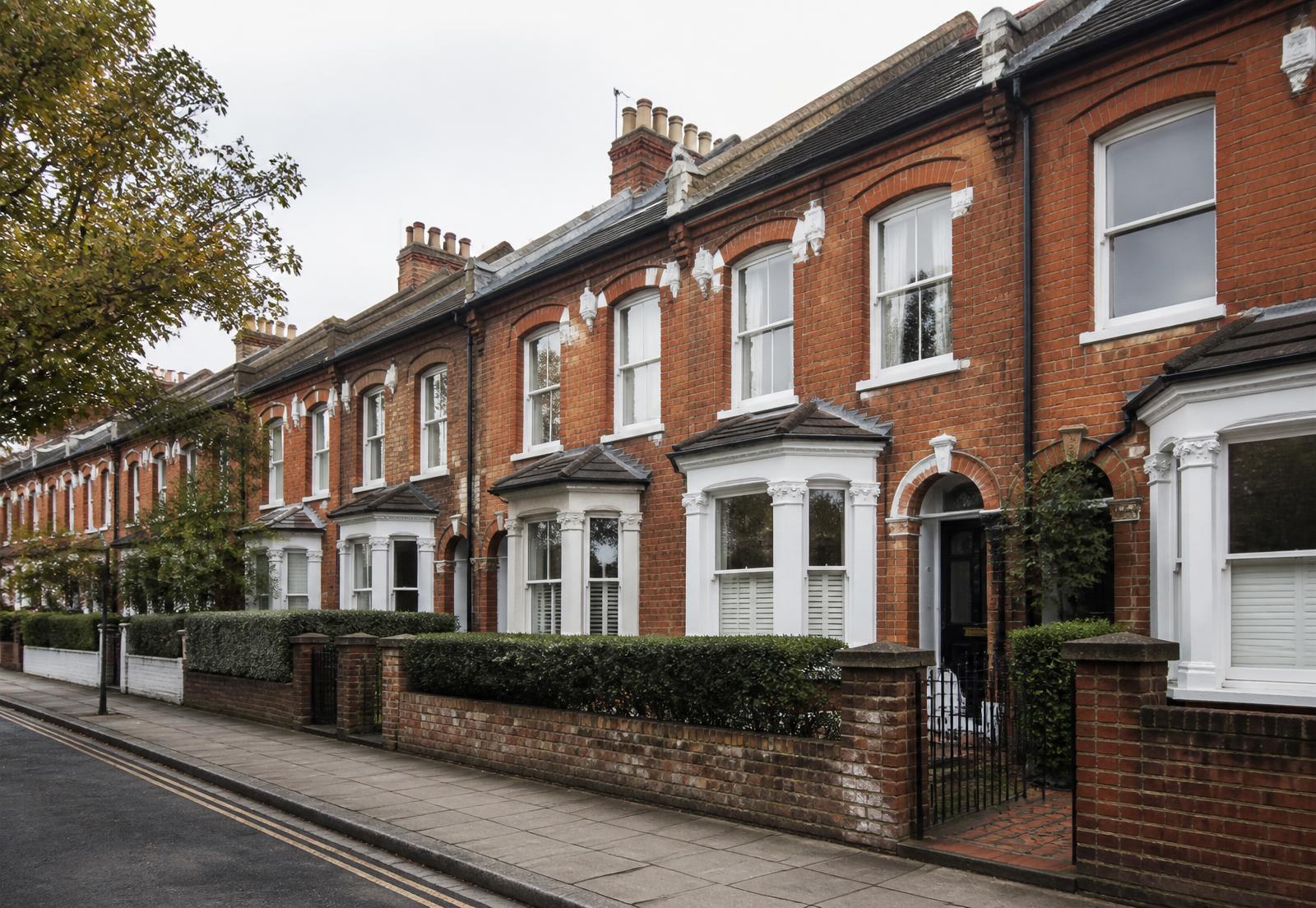 Row of traditional red-brick UK terraced houses on a residential street